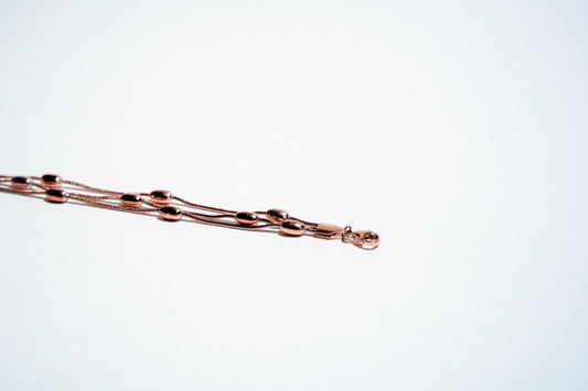 Serene Whispers: Triple-Strand Rose Gold Bead Bracelet